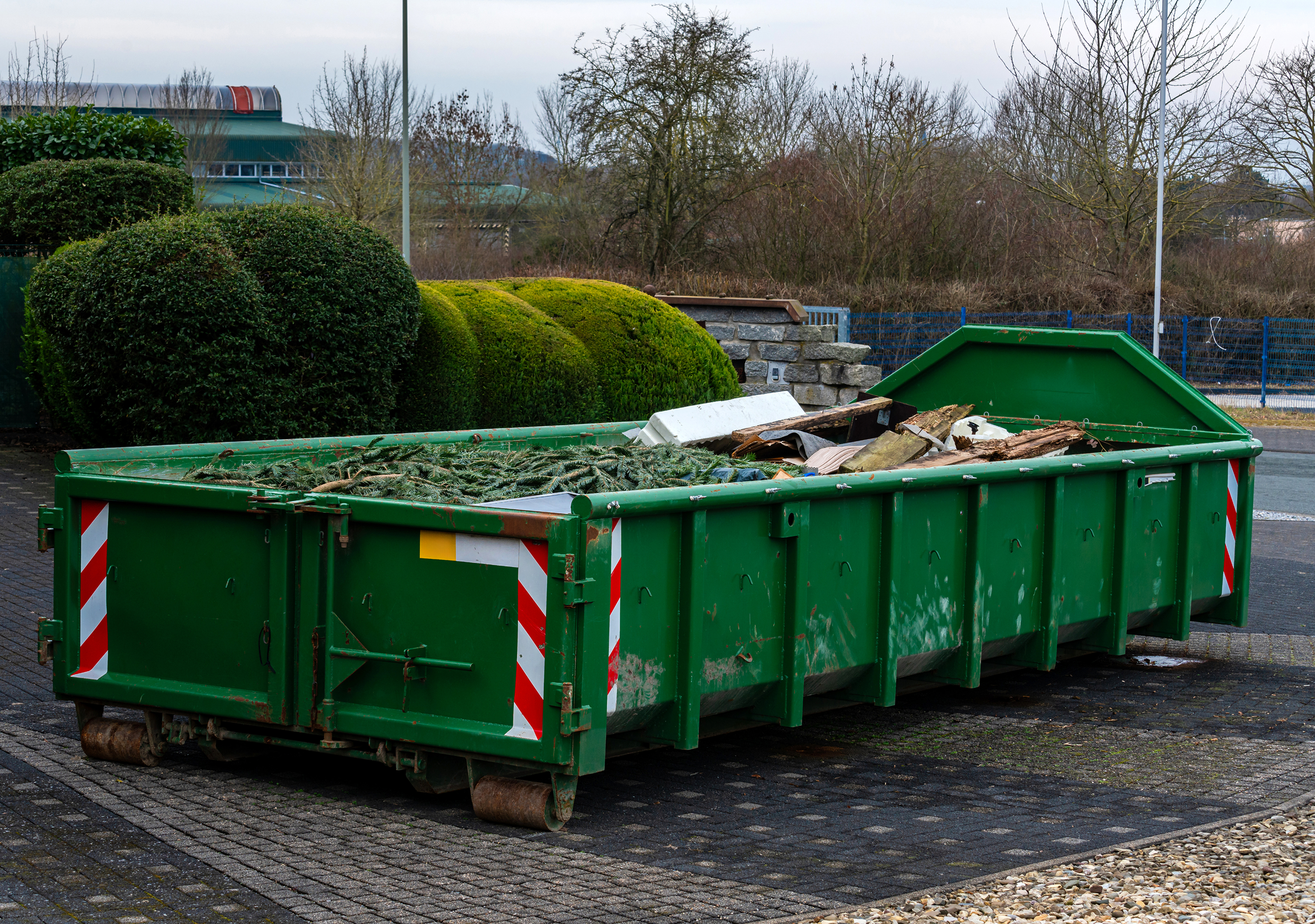 Green dumpster filled with construction debris.