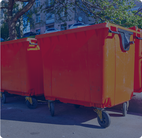 Orange trash bins on a city street.
