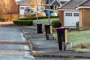 Street with trash bins in residential area.